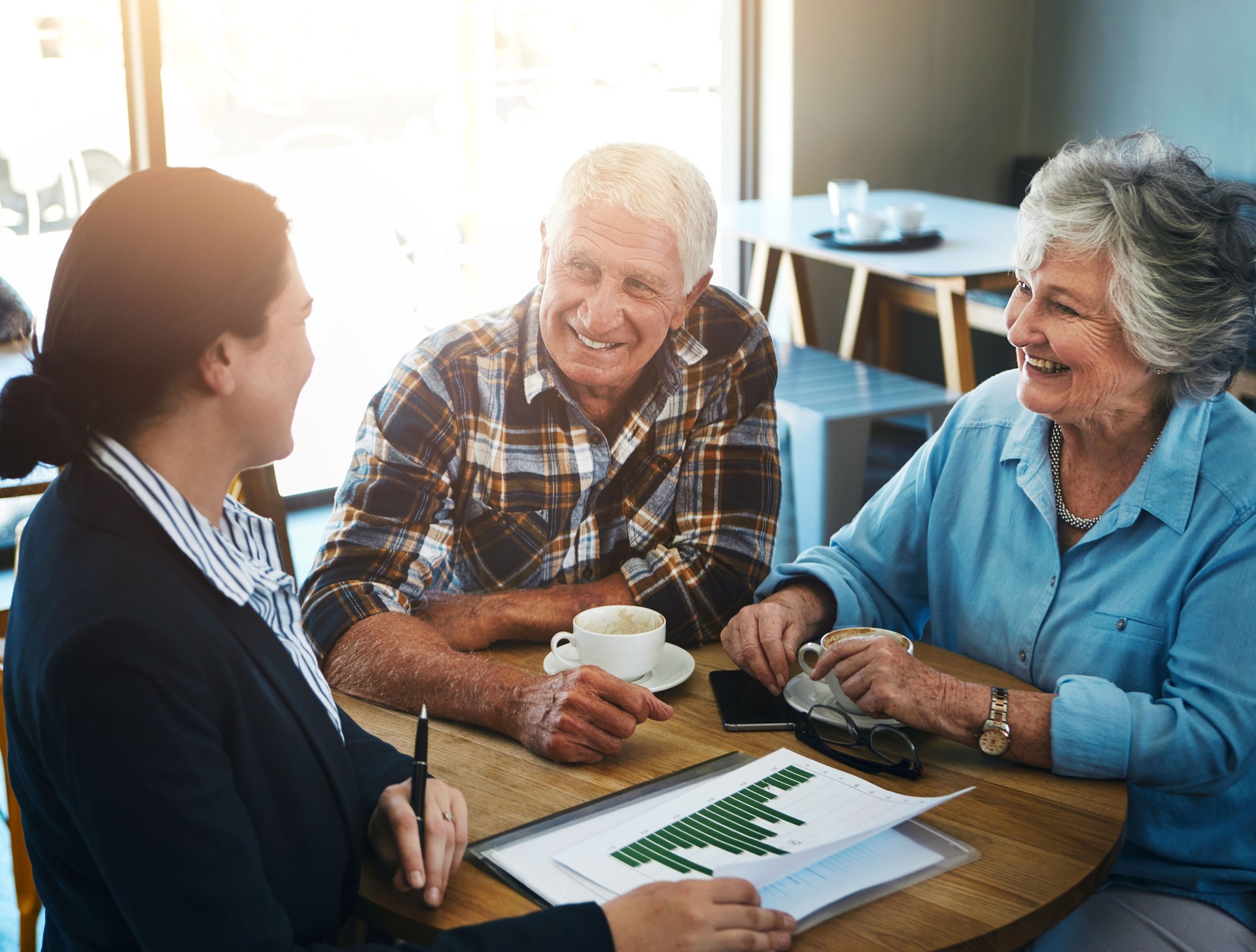 Senior, couple and financial advisor talking with paperwork, cafe and meeting for investment conversation. Statistics, graphs and finance with people, retirement plan and planning with professional